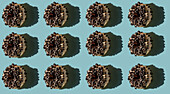 Top view of many white donuts covered with bits of oreo biscuit on blue background