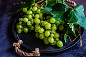 From above of heap of fresh ripe grapes placed on dark background