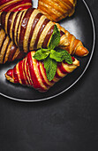 From above of assorted sweet croissants served in basket on table for breakfast