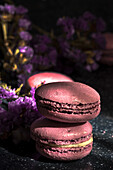 Pair of delicious sweet macaroons of purple color stacked together on sunlit table in morning