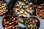 From above bowls with different kinds of nuts on concrete table background