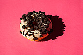 Weiße Donuts mit Oreo-Schokoladenstückchen auf rosa Hintergrund