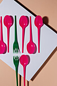 Overhead view of colorful eco friendly cutlery on pastel background