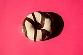 Weiße Donuts mit Oreo-Schokoladenstückchen auf rosa Hintergrund