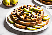 Appetizing homemade biscuit cake with dried berries and apple slices on white plate