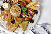 High angle of assorted tasty Arabic food with salsa and fresh mint leaves near almonds during Ramadan holidays