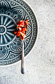 From above vintage ceramic plate with spoon with peach jam on the concrete table