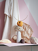 Still life with peach and stones on pink background