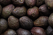 Top view full frame of whole ripe brown avocados placed together as background