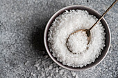 From above cooking concept with sea salt in ceramic bowl on concrete table