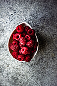 From above close up of ripe raspberries in the bowl