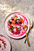 Top view of plate with delicious bright Italian salad made of vegetables and fruits served on table with sauce and gold silverware