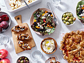 Vegetarisches Abendessen mit verschiedenen Snacks und Gerichten: Salatteller, Bruschetta, gebratenes Gemüse und ein Kuchen