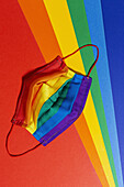 Helle Textilmaske mit gestreiftem Regenbogenornament während der Pandemie COVID 19 von oben