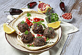 Traditional homemade beef and lamb meatballs with arabic bread, tomato sauce, pomegranate and aromatic herbs. Halal food