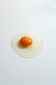 Top view of fresh raw chicken egg placed on white background in bright studio