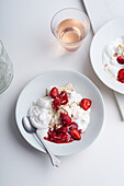 Draufsicht auf eine Nachspeise mit Beeren, Baiser und Schlagsahne. Eton's mess mit Erdbeeren, süße Leckerei mit Sommerstimmung