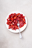 Sugar-coated sliced strawberries on a plate. Cooking dessert or jam