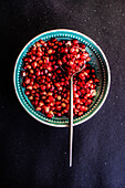 From above ripe organic pomegranate fruit seeds in ceramic plate