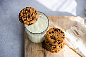 Healthy oat cookies with chocolate and glass of yogurt on the concrete or stone table