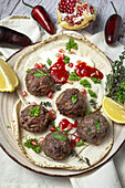 Traditional homemade beef and lamb meatballs with arabic bread, tomato sauce, pomegranate and aromatic herbs. Halal food