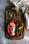 From above glasses of cold vodka drink served with salo and fermented cucumber on the plate