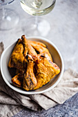 Georgian chicken tabaka dish served for the dinner with white dry wine in glass