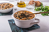 High angle of bowl with tasty chickpea soup served for lunch on paper napkin near spoon