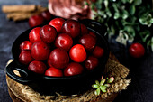 Bowl with fresh sweet plums served on black table