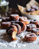 Appetitanregende geliehene süße Donuts auf Faden auf dem Tisch mit gestreutem Puderzucker
