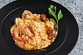 From above of appetizing rice with assorted seafood served on plate on table in restaurant