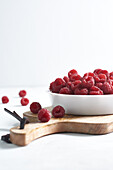 Side view of raspberries in a bowl on a wood isolated on a white background
