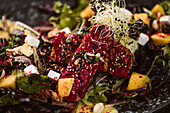 Plate with tasty vegetarian Indonesian salad with fresh mango and cashew cheese slices near soybeans and condiments covered with basil vinaigrette