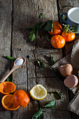 From above of assorted ingredients for tangerine mousse arranged on wooden table in kitchen