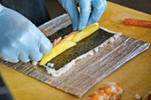 Stock photo of unrecognized chef in japanese restaurant preparing sushi plate.