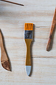 Top view set of pottery and painting brushes placed on wooden table in workshop