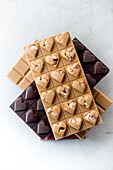 Top view of delicious chocolate candies with nuts in shape of heart on white background