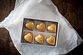 Draufsicht auf süße bunte Schokoladenbonbons in einer Schachtel auf einem Holztisch