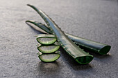Piece and leaf of green aloe vera placed on gray background in studio