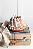 Delicious homemade cake on vintage suitcase against white background