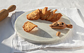 Top view of delicious Almond Tiles cookies placed on plate on tablecloth