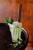 Cold Cucumber Splash cocktail consisting of apple and lemon juice pear puree garnished with mint leaves