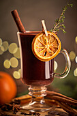 Glühwein oder Weihnachtspunsch, serviert in einem Glasbecher mit getrockneten Orangenscheiben