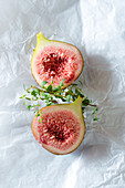 Overhead view of tasty ripe fig slices with aromatic thyme sprigs on baking paper