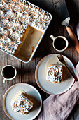 Von oben gesehen drei Milchkuchen in einer Auflaufform und Teller mit Tassen mit starkem Kaffee auf einem Holztisch