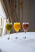 Assorted colorful freshly squeezed juices in elegant glasses placed on table in restaurant