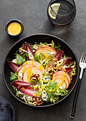 Von oben bunter köstlicher Salat mit Endivien, Apfel und Roquefortkäse auf dunklem Hintergrund