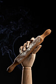 Rolling pin in flour in wooden hand on black background in studio showing concept of culinary