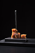 Gourmet quince jelly paste in ceramic plate on black background with fork