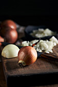 Rustic bowl with pieces of cut onion placed near knife on lumber table in kitchen